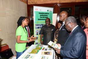 Picture of Tola, a youth Agripreneur, explaining the IYA program to the Minister of Agriculture, H.E Henri Eyebe Ayissi