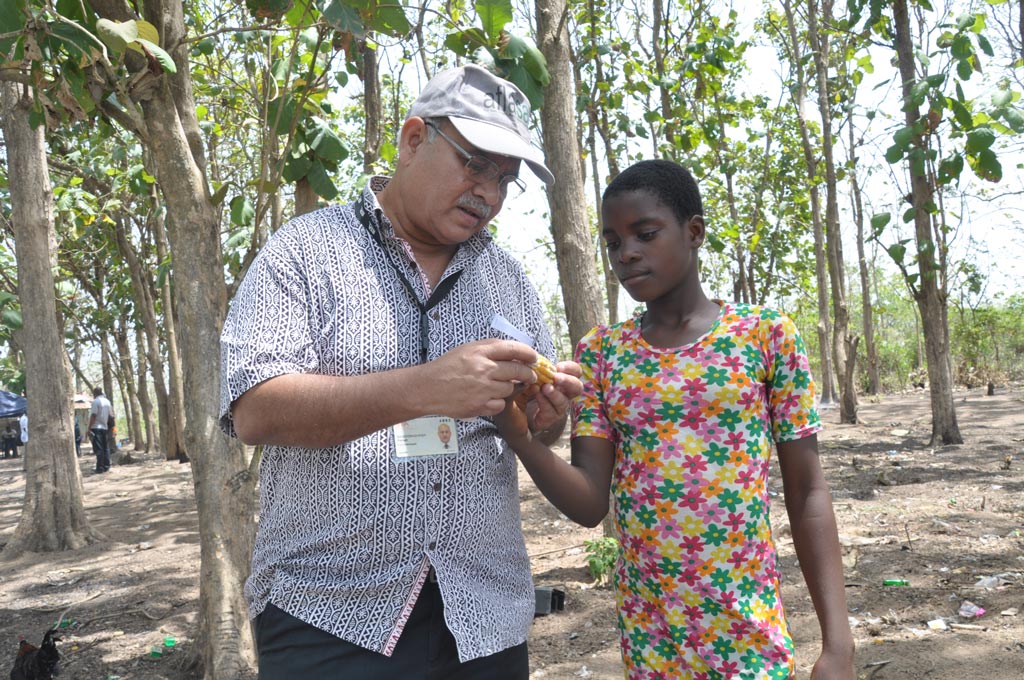 Picture of Ranajit Bandyopadhyay shows a maize cob to a young farmer.