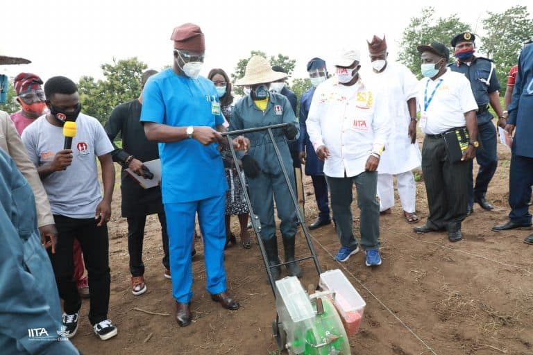 A STEP-trained student showing Governor Seyi Makinde how to use a planter.