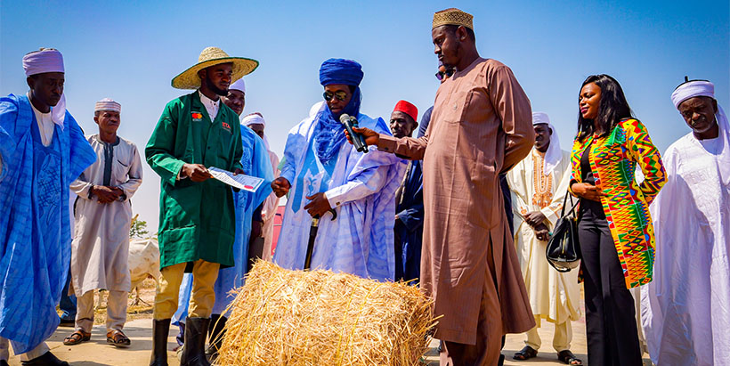 Ardo Bamanga Dalil presenting some high-quality feed to a participant in the feed and fodder unit.