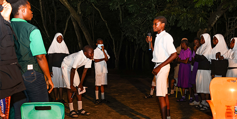 Students having fun at the bonfire place during the camping.