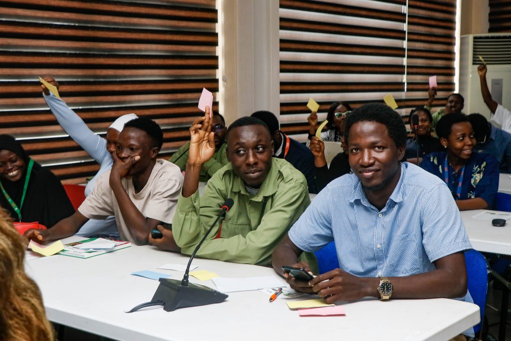 participants engaging in the audience colour-card voting exercise.